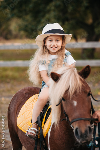 Adorable little girl riding a pony at summer © sushytska