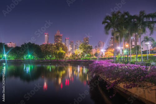 Lake with Calm Water Reflecting Nearby Buildings in South Part of Benjakiti Public Park at Night in Bangkok, Thailand © kaycco