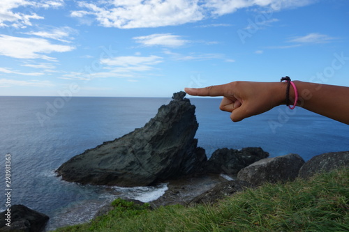 Finger stubst Stein vom Fels im meer 