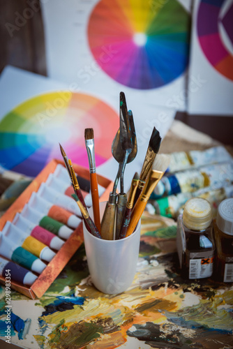 set of new paintbrushes with acrylic colors in the background