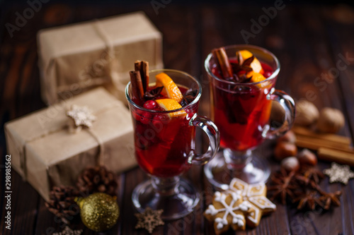 Christmas and New Year cozy holiday composition with hot mulled wine, gingerbread cookies and gift boxes. Winter holidays celebration concept