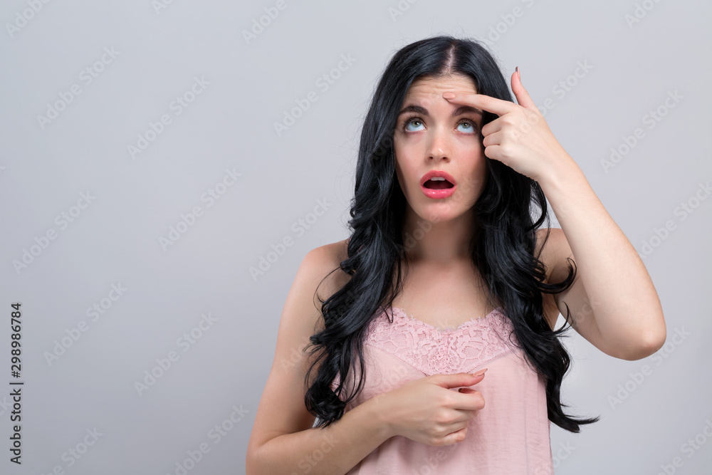 Young woman with skin blemish theme on a gray background Young woman with skin blemish theme on a gray background