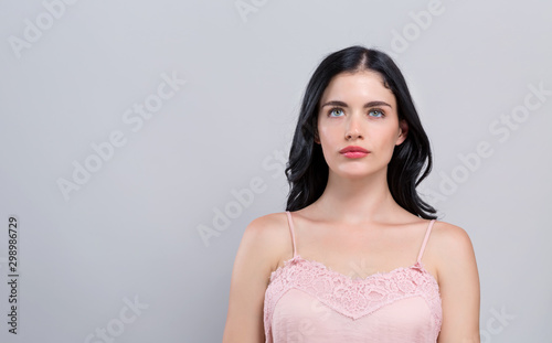 Beautiful young woman in skin care theme on a gray background