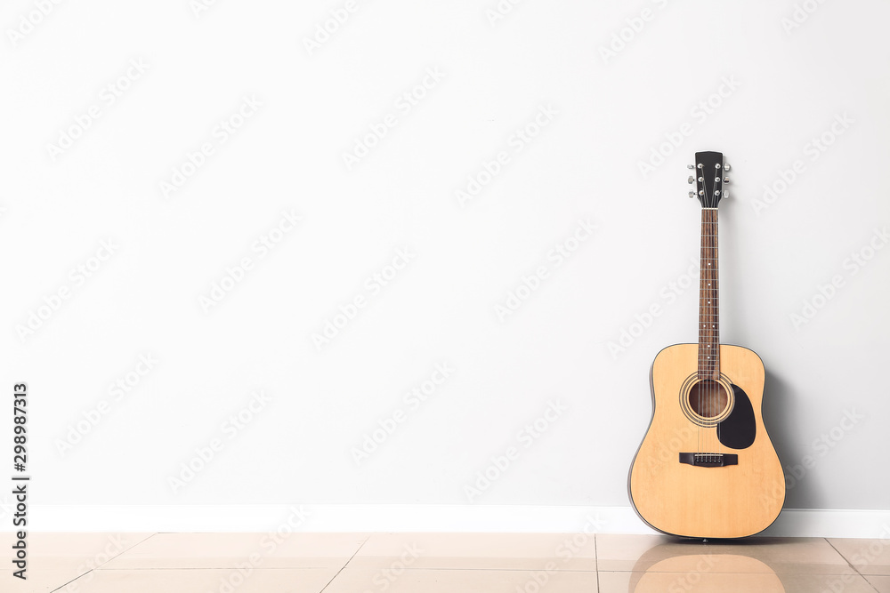Nowoczesna gitara akustyczna w pobliżu białej ściany