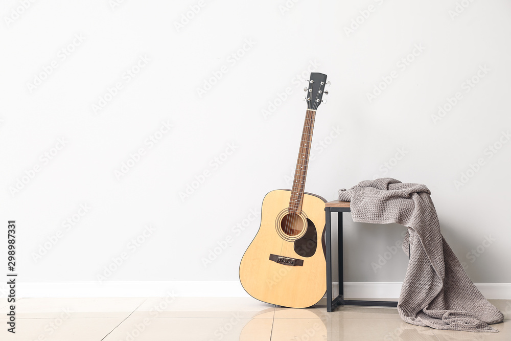 Fototapeta Modern acoustic guitar near white wall