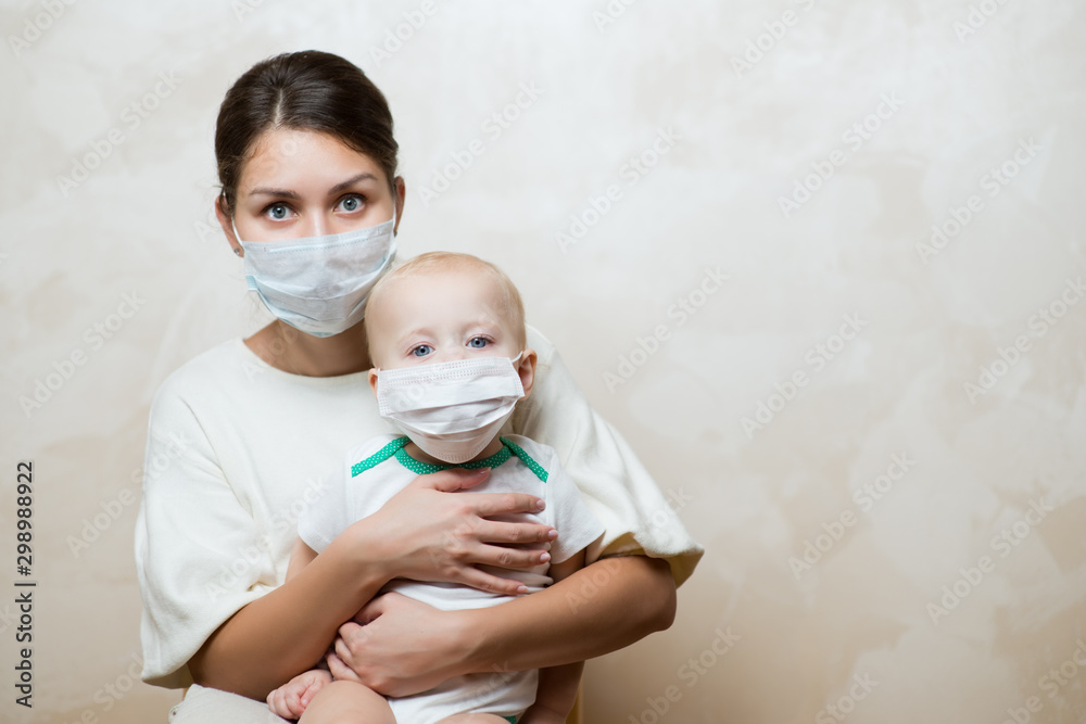 mother is sitting with baby in medical masks