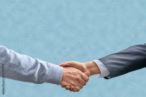 handshake on light blue background. verbal agreement concept