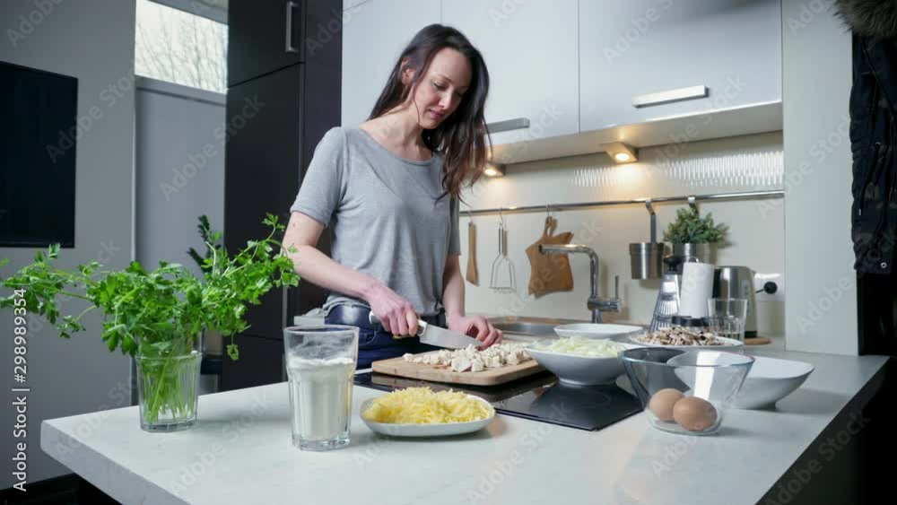 Young woman cutting vegetables in kitchen Young woman cutting vegetables in kitchen