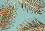 Gold painted date palm leaves on desaturated turquoise background