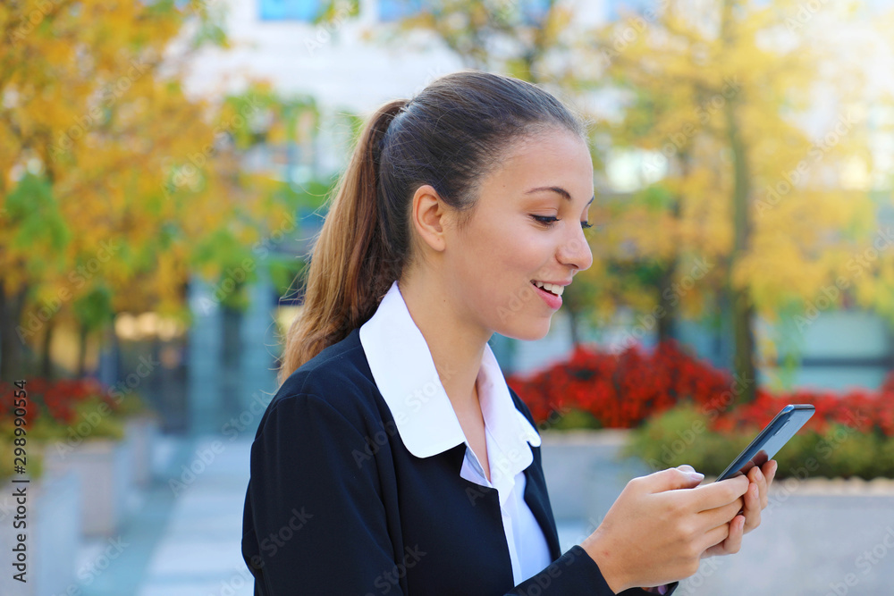Young business girl typing on mobile phone outdoors. Young business girl typing on mobile phone outdoors.