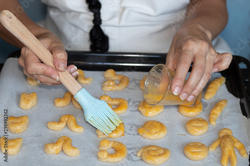 Woman's hands making marzipan, grinding almond, pouring sugar and egg, stirring everything, making individual portions, and spreading yolk