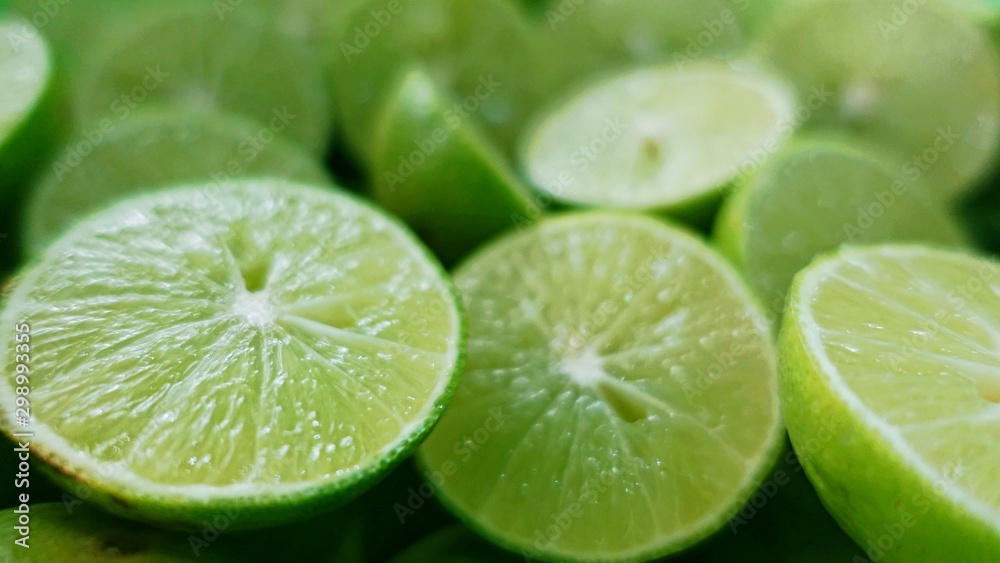 Lime Background. Close up shot of limes. Selective Focus of sliced lime. Lime is a kind of fruit. The result is very sour for cook the Thai food style Lime Background. Close up shot of limes. Selective Focus of sliced lime. Lime is a kind of fruit. The result is very sour for cook the Thai food style