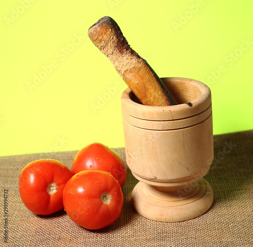 Puerto Rican wood morter and pestle with red tomatoes.