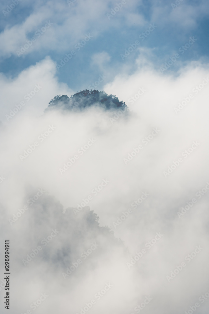 Low clouds engulfing stone pillar in Tianzi mountains in Zhangjiajie