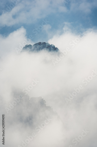 Low clouds engulfing stone pillar in Tianzi mountains in Zhangjiajie