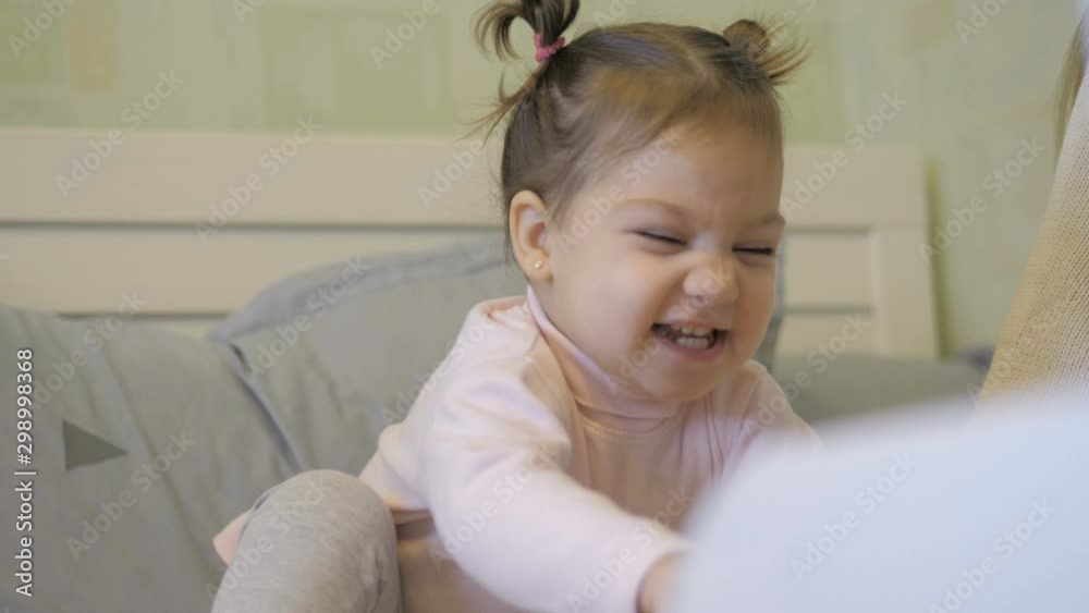 Happy mother and daughter reading a book together in bed Happy mother and daughter reading a book together in bed