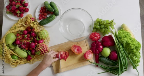 Close Up Of Woman Cutting Fresh Tomatoes In Her Kitchen. Woman makes a salad