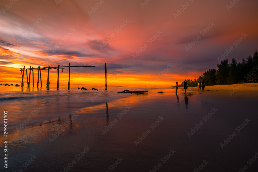 The blurry background of the colorful night sky on the large lake, the brightness of the light that hits the water surface and the wind blows cool, with the rotten wooden bridge over time, a viewpoint