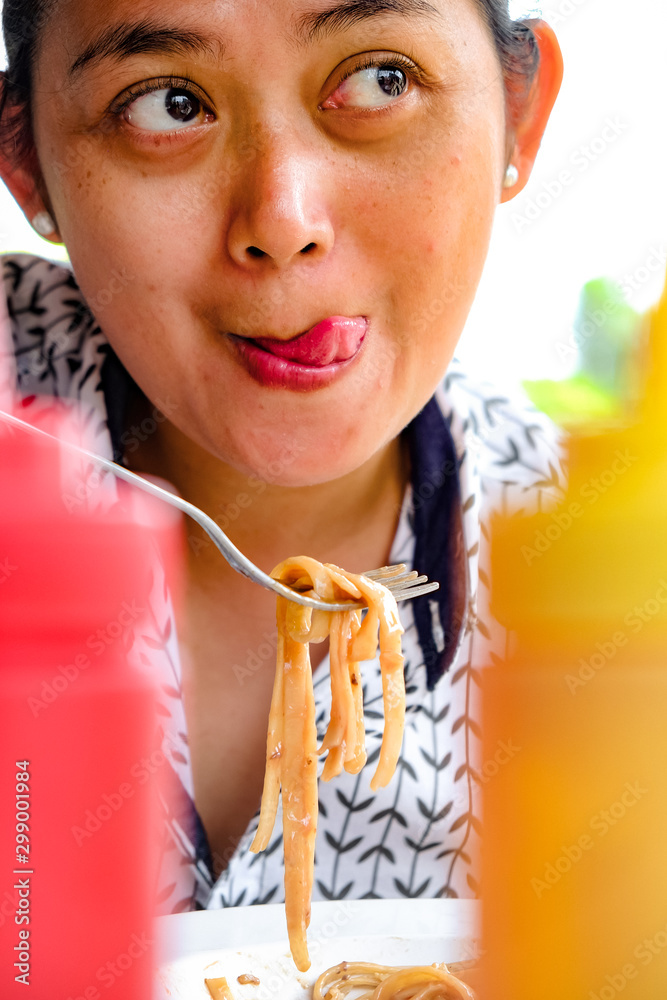 Facial Expression of an Asian Adult Woman Who Really Enjoy Eating Delicious and Tasty Pasta in A Restaurant or Cafe