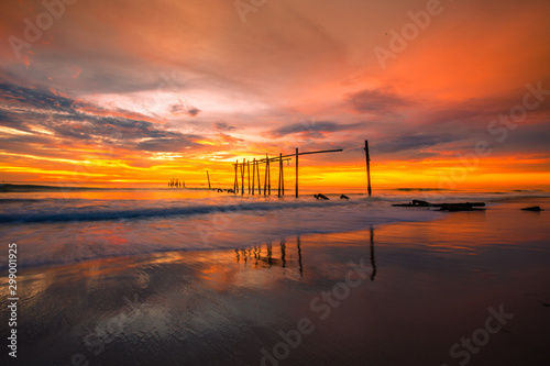 The blurry background of the colorful night sky on the large lake, the brightness of the light that hits the water surface and the wind blows cool, with the rotten wooden bridge over time, a viewpoint