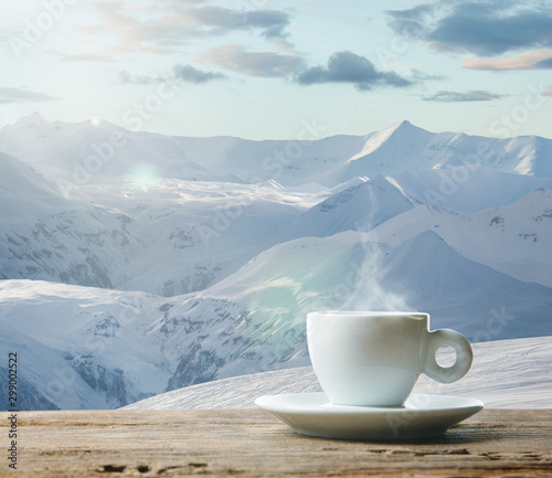 Single tea or coffee mug and landscape of mountains on background. Cup of hot drink sunshine look and clear sky in front of it. Warm in spring day, holidays, travel, adventure time. © master1305