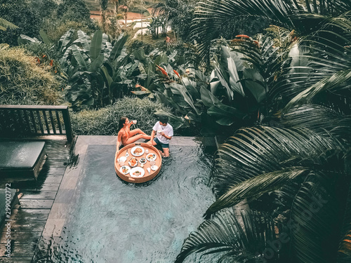 Floating breakfast in infinity pool on paradise swimming pool, morning in the tropical resort Bali, Indonesia