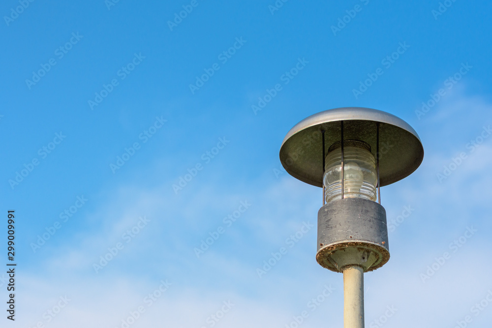 Looking up old grunge street lamp against the blue sky and clouds. Copy space wallpaper.