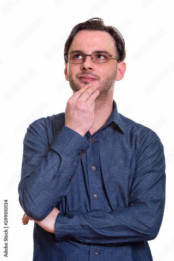 Studio shot of formal young man thinking while wearing eyeglasse Studio shot of formal young man thinking while wearing eyeglasse