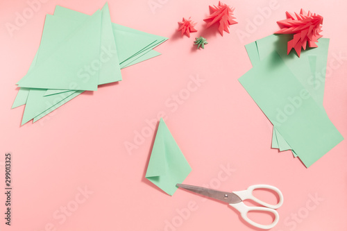 Foto A process of making 3D fir tree from green paper on pink background