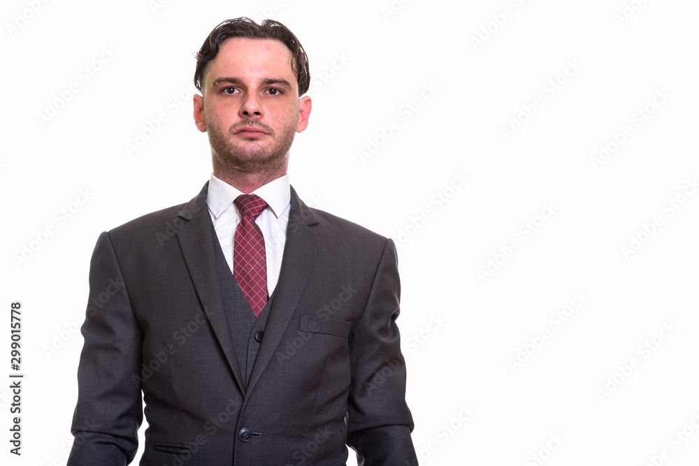 Studio shot of young businessman in suit looking at camera Studio shot of young businessman in suit looking at camera
