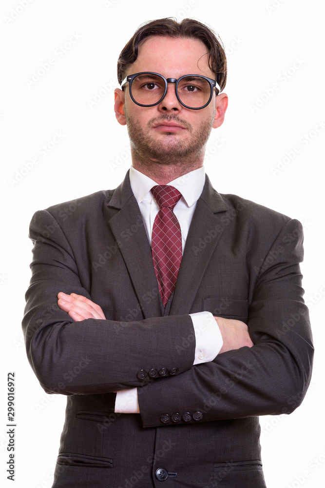 Studio shot of young businessman wearing eyeglasses with arms cr Studio shot of young businessman wearing eyeglasses with arms cr
