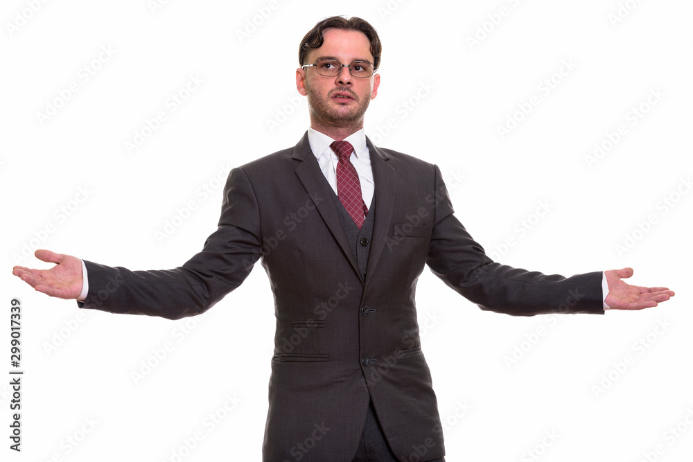 Studio shot of young businessman showing something with both han Studio shot of young businessman showing something with both han