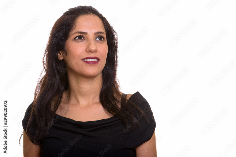 Studio shot of happy Persian woman smiling while thinking Studio shot of happy Persian woman smiling while thinking
