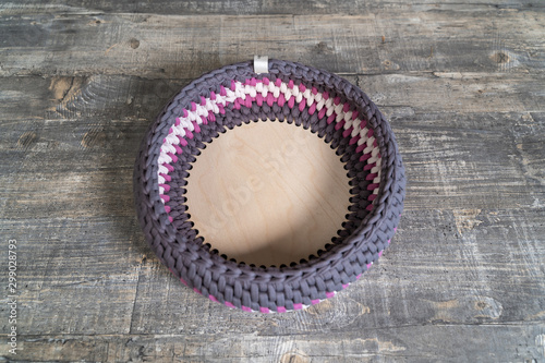 Knitted crochet basket on grey wooden table. top viewStill life photo of nordic interior details. Cosy place. Handmade. Background for design.