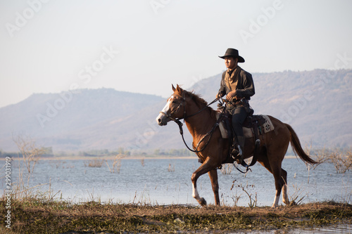 Tableau sur toile cowboy and horse at first light,mountain, river and lifestyle with natural light