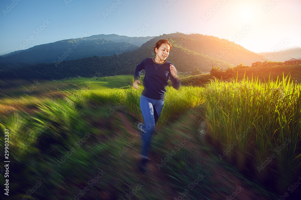 Move-motion style with women trailing running in beautiful light flare on mountains with rice terraces background Move-motion style with women trailing running in beautiful light flare on mountains with rice terraces background