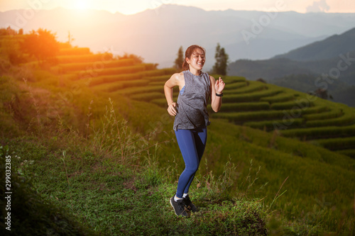 women trailing running in beautiful light flare on mountains with rice terraces background