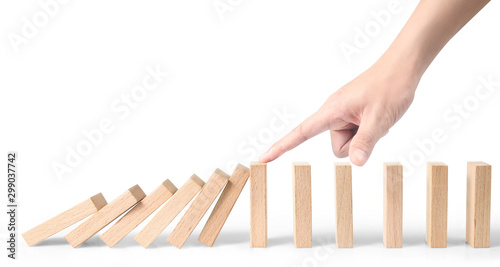 Fotografie Hand stopping the Domino effect stopped by unique