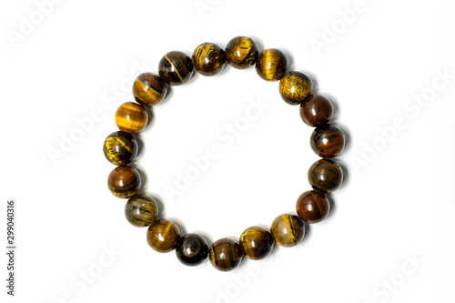 Close up of lucky stone bracelet made from tiger s eyes stone isolated on white background.