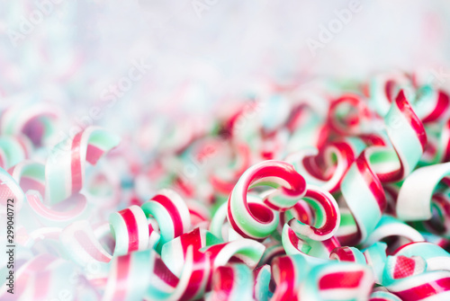 Red, white and green striped christmas candy. White, blurred background with place for text.