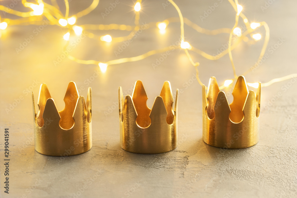 Three gold crowns, symbol of Tres Reyes Magos  ( Three Wise Men) who come bringing gifts for the kids on Epiphany or Dia de Reyes Magos. - obrazy, fototapety, plakaty 