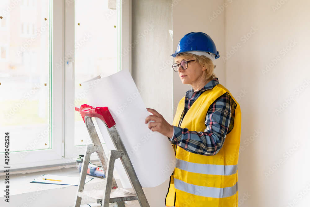 Woman Builder in the room of the house making repairs. Woman Builder in the room of the house making repairs.