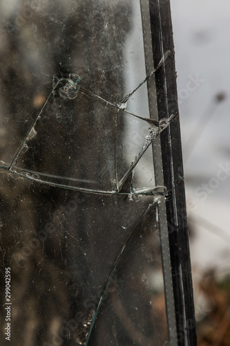 Dirty broken glass in the window of an abandoned house. Large cracks of broken glass, windows