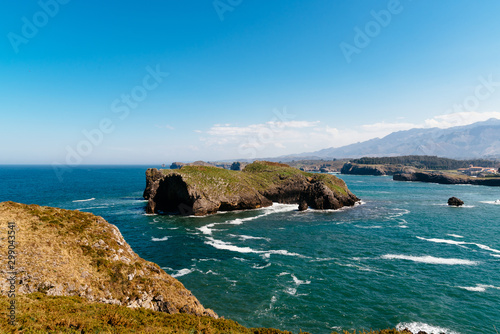 Scenic view of sea against blue sky in rocky coast photo