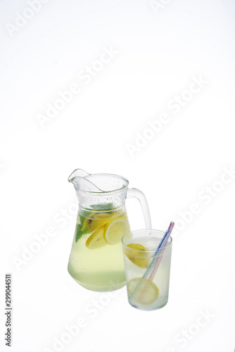 Lemonade jug with ice and glass on a white background. Isolated, copyspace
