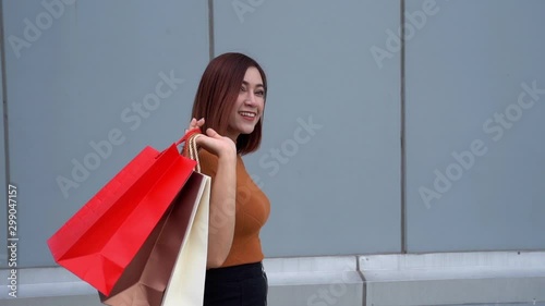 slow-motion of happy woman walking with shopping bags photo