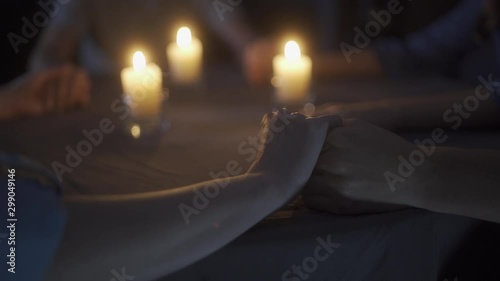 People hold hands during a seance photo