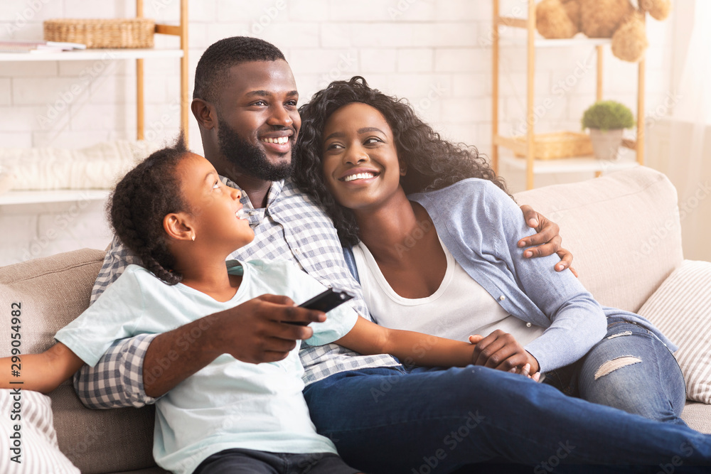 Happy afro family watching tv, relaxing together at home Happy afro family watching tv, relaxing together at home
