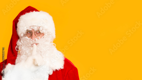 Funny Santa Claus making shh sound with finger in front of mouth