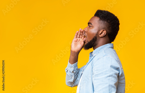 Vászonkép African american man making announcement, shouting at copy space